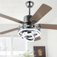 a ceiling fan that is hanging from the ceiling in a room with white walls and windows