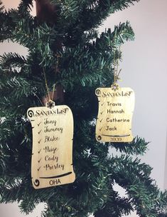 two wooden tags hanging from a christmas tree with writing on them that read santa's list