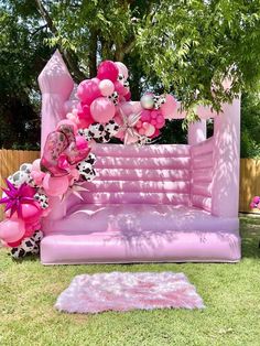 an inflatable couch is decorated with pink and white balloons for a birthday party