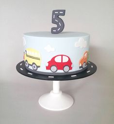 a birthday cake with cars on it and the number five in the middle is decorated