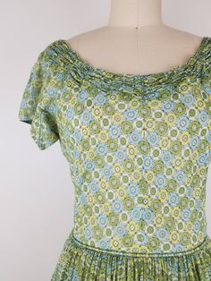 "Lovely green fit and flare dress from the late 40s I think (from the zipper). It has cute gathering around the neck line. Skirt is fully gathered at waist. Dress goes over the head and closes with a 11 inch 'Talon' brand green metal zipper on the side. The bodice is fully lined, but the skirt is not and the fabric is semi sheer so it may require a petticoat underneath (last photo I tried to show my hand thru the fabric. Photographed with white crinoline underneath). Nice construction of the arm Green Retro Vintage Dress, Fitted Green Vintage Dress, Green Vintage Dress With Ruffles For Garden Party, Green Vintage Style Dress For Summer, Green Vintage Dress For Summer, Green Retro Vintage Dress With Short Sleeves, 1950s Green Short-sleeved Dress, 1950s Style Green Vintage Dress For Spring, 1950s Green Short Sleeve Dress