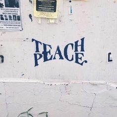 there is a sign that says teach peace on the wall