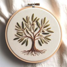 an embroidered tree is shown on a white surface