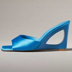 Elevate your footwear with these enchanting blue satin square toe mules. Adorned with a sculptural wedge heel, they blend sophistication and style effortlessly, perfect for any chic ensemble. Color: Blue Material: Satin Patent leather Heel Type: Sculptural wedge heel Heel height: 2.99'' / 76 mm approx Product measurements were taken using size 8. Please note that measurements may vary by size. Toe: Open square toe Sculptural wedge heel design Handcrafted US sizing. Fits true to size. Blue Sandals With Sculpted Heel And Square Toe, Blue Wedge Sandals For Formal Summer Events, Blue Wedge Sandals For Summer Formal Events, Blue Heels With Deep Heel Cup For Summer, Blue Mules With Sculpted Heel For Spring, Chic Blue Wedge Sandals With Open Heel, Blue Mules For Summer Evenings, Modern Blue Mules For Summer, Formal Summer Wedge Sandals With Square Toe