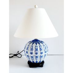 a blue and white lamp sitting on top of a table next to a light shade