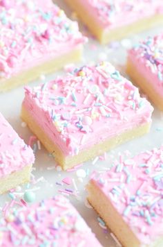 pink frosted dessert squares with sprinkles on top