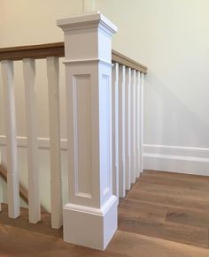 an empty staircase with white railings and wood flooring