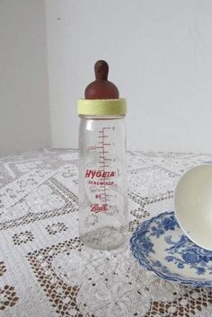 a baby bottle sitting on top of a table next to a plate