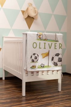 a baby's crib with soccer themed wallpaper