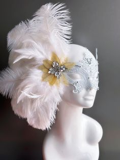 Our women's white laser cut metal masquerade mask, adorned with delicate white feathers and a gold crystal brooch, offers you the opportunity to add a touch of enchanting gold glitter to the mask. Whether you're attending a grand masquerade ball, a themed gala, or simply looking to add a touch of elegance to your attire, this mask ensures you'll be the center of attention. Age Group/Gender - Adult/Women Size/Type - One size fits all adults Mask Color - White Mask Material - Laser cut metal Elegant Wedding Masks, Elegant White Masquerade Mask For Carnival, Elegant White Masquerade Mask For Mardi Gras, Elegant Feathered Masquerade Mask For Mardi Gras, Gold Headpiece For Masquerade And Carnival, Gold Headpiece For Carnival Masquerade, Elegant White Masquerade Mask For Weddings, White Wedding Eye Mask, White Eye Mask For Wedding