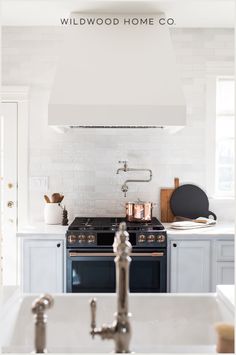 Embrace open-concept living with this dream white kitchen remodel. Featuring a beautiful tile backsplash in shades of white and a porcelain farmhouse sink. The custom range hood serves as the central focal point, while the large island banquette enhances the flow between the kitchen and dining area. Unobstructed windows let in plenty of natural light, making the space feel bright and inviting. Ideal for those who love a clean, organized kitchen with a warm, welcoming atmosphere. Island Banquette, Kitchen With Tile Backsplash, Dream White Kitchen, Beautiful Tile Backsplash