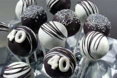 chocolate covered cake pops with white frosting and silver sprinkles on top