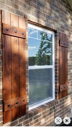 a brick building with wooden shutters and windows