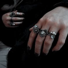 a woman's hand with three rings on her fingers and one ring in the middle