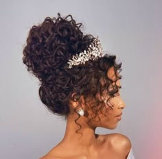 a woman with curly hair wearing a tiara