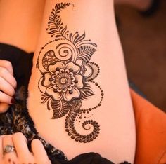 a close up of a woman's stomach with henna tattoos on it and her hands