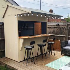 an outdoor bar with stools and barstools on a deck in a backyard