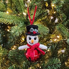 a snowman ornament hanging from a christmas tree