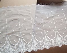 two pieces of cloth with white lace on them