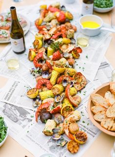 a table topped with lots of different types of food next to a bottle of wine