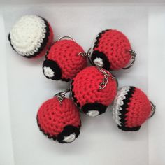 four crocheted keychains with black, white and red balls on them