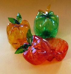 three colorful glass apples sitting next to each other