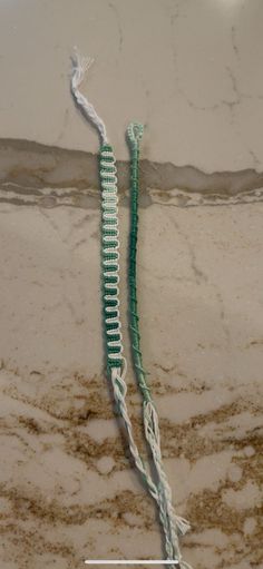 two pieces of green string sitting on top of a marble counter next to each other