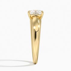 a yellow gold ring with a diamond on the top and side stones in the middle