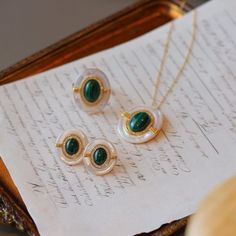 The vintage, luxury look of intricate green Malachite, combined with the gorgeous iridescent Mother of Pearls, paired in this new arrival set, is fit for royalty. Perfect for a special occasion or a night on the town, these elegant earrings will grant you timeless beauty. Material: Gold Vermeil on 925 Sterling Silver, Mother of Pearls with Green Malachite Style: earrings, necklace and ringWeight:7.47gNecklace length: around 45cm Note: Our jewelry is handmade. Naturally formed shapes of freshwate Luxury Mother Of Pearl Jewelry With Matching Earrings, Luxury Green Round Jewelry, Elegant Oval Jade Jewelry, Exquisite Emerald Jewelry With Cabochon, Exquisite Emerald Cabochon Jewelry, Luxury Green Cabochon Jewelry, Exquisite Jade Jewelry For Formal Occasions, Round Emerald Jewelry Sets As Gifts, Elegant Green Plated Jewelry