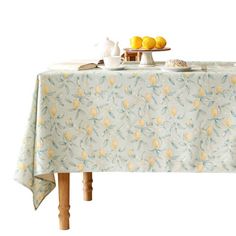 a table with lemons on it and a tea pot sitting on top of it