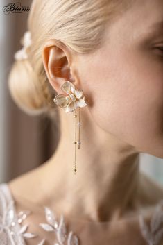 a close up of a person wearing ear clips with flowers on the back of their ears