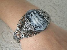 Triple Goddess Cuff Bracelet This beautiful silver plated filigree cuff bracelet has silver plated filigree accents and a triple goddess cameo. Adjustable. Silver Gothic Bangle, Silver Gothic Cameo Jewelry, Nickel-free Bohemian Cuff Bracelet For Wedding, Silver Metal Cameo Jewelry, Bohemian Nickel-free Cuff Bracelet For Wedding, Silver Cameo Bracelet For Gifts, Victorian Cuff Bracelet For Wedding, Elegant Silver Bracelet With Cameo, Victorian Bangle As Gift