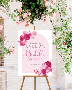 a sign that says welcome to the bridal shower with pink flowers and greenery