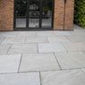 an outdoor patio with stone pavers and black doors