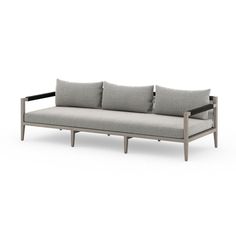 a gray couch with three pillows on it and two arms that are connected to each other