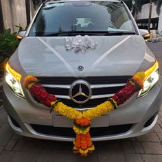 a mercedes benz car decorated with flowers and ribbons