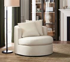 a white chair sitting on top of a rug next to a lamp