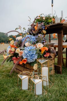 flowers and candles are on the grass near a table