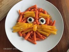 a plate that has carrots in the shape of a face on top of it