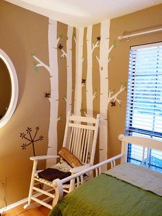 a white rocking chair sitting next to a bed in a bedroom