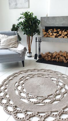 a living room filled with furniture and a fire place covered in wood logs on top of a rug