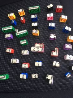 many different colored legos are arranged on a black surface with white letters and numbers