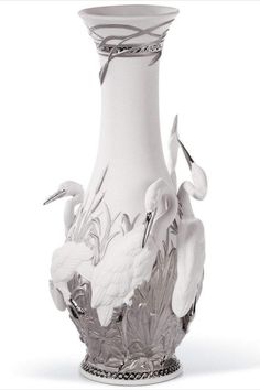 a white vase with two birds on the front and one bird on the back, sitting against a white background