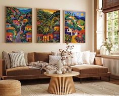 a living room with two paintings on the wall and a coffee table in front of it