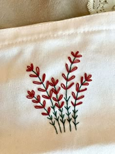 embroidered red flowers on white cloth with lace