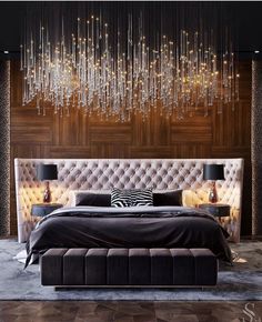 a large bed sitting under a chandelier in a bedroom