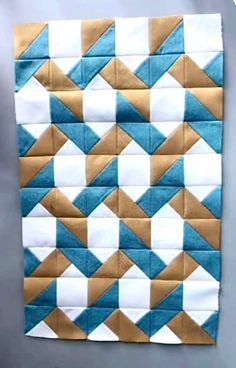 a blue and white quilted wall hanging on the side of a gray table top