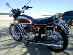 a red and black motorcycle parked in a parking lot