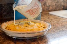 someone pours milk into a casserole dish