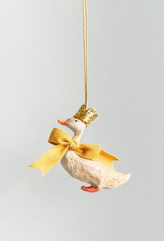 a bird ornament hanging from a string with a bow on it's head